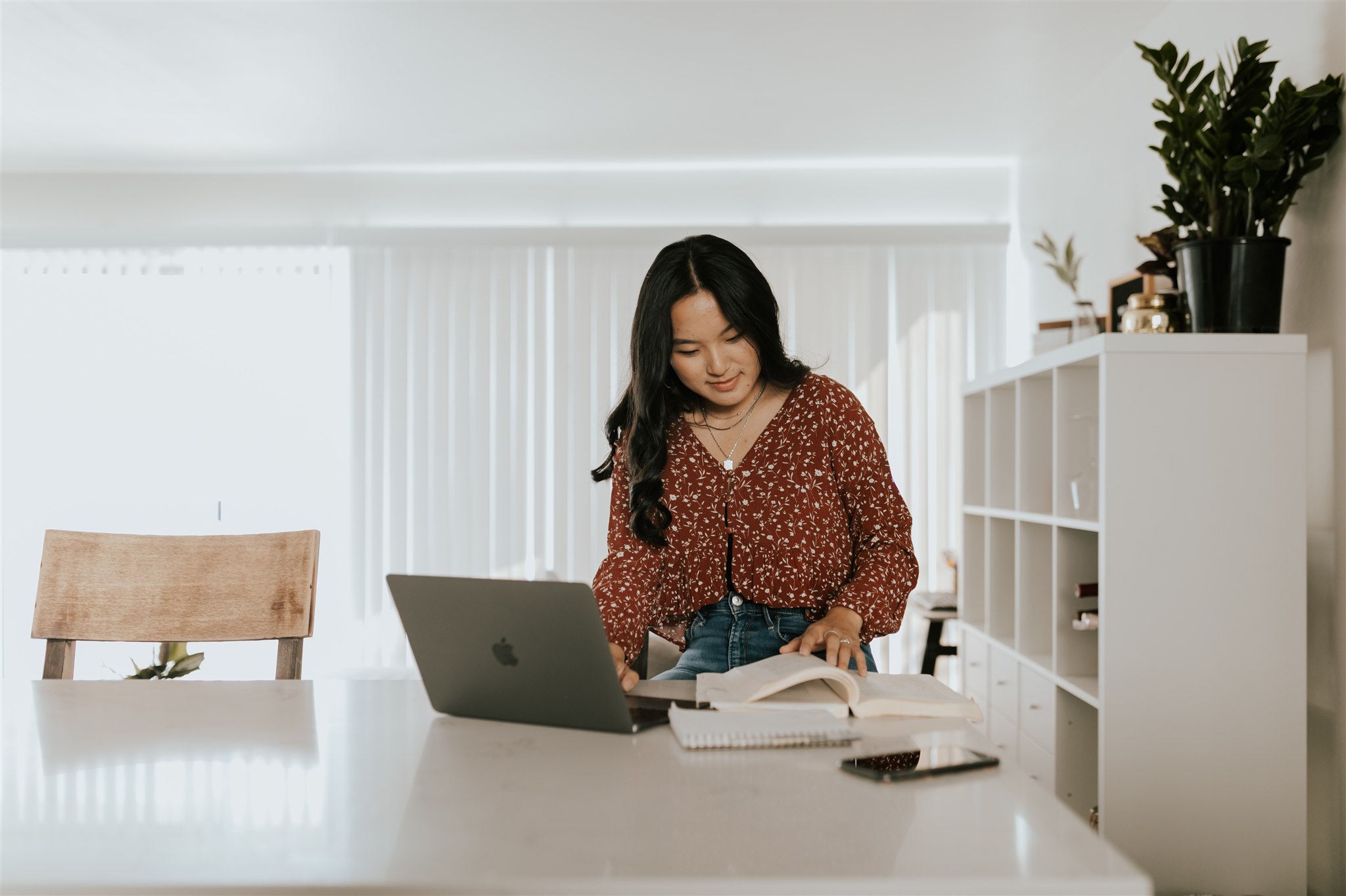 A young woman works at her laptop.