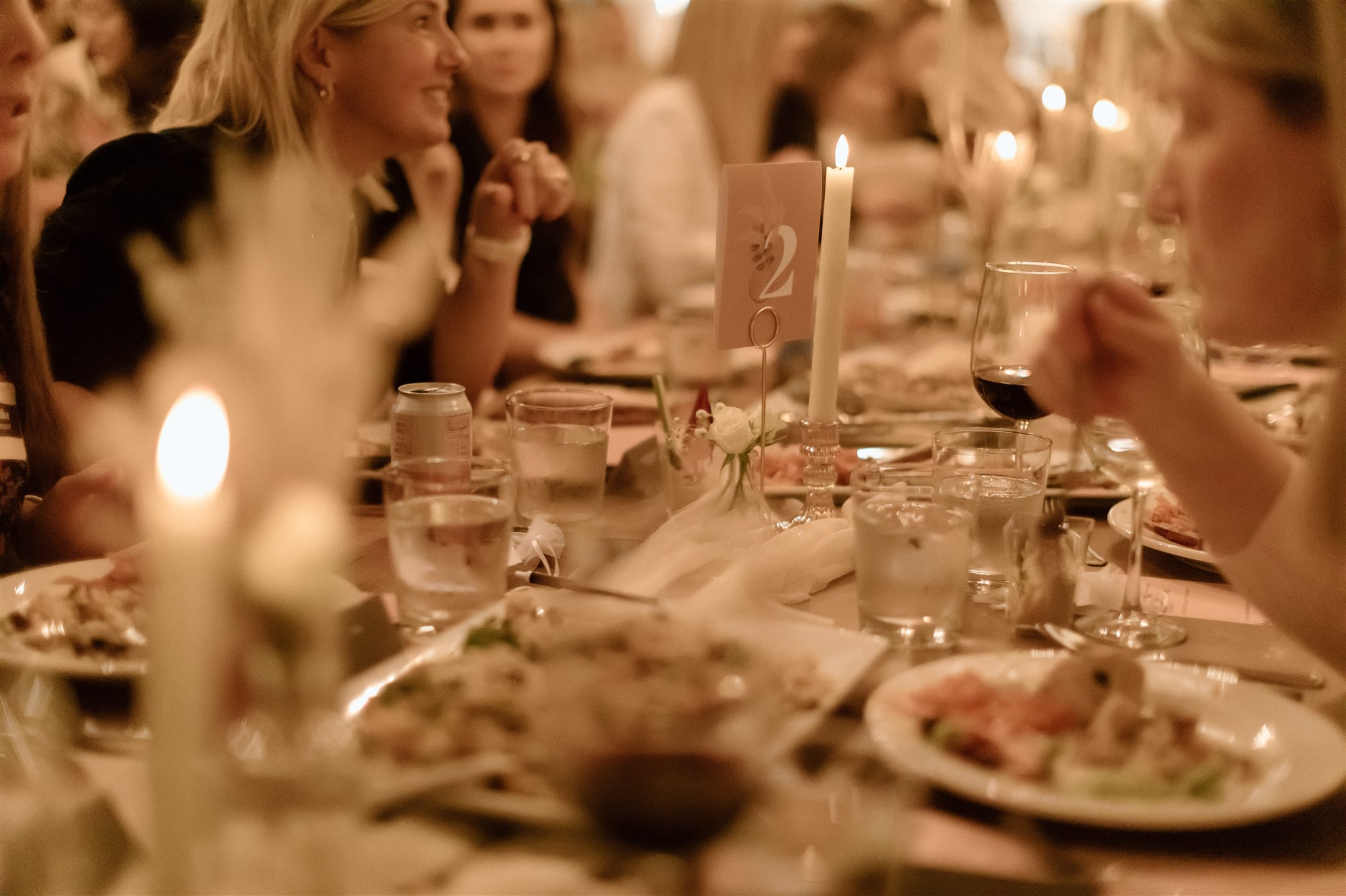 An elegant dinner is set at long rectangular tables.