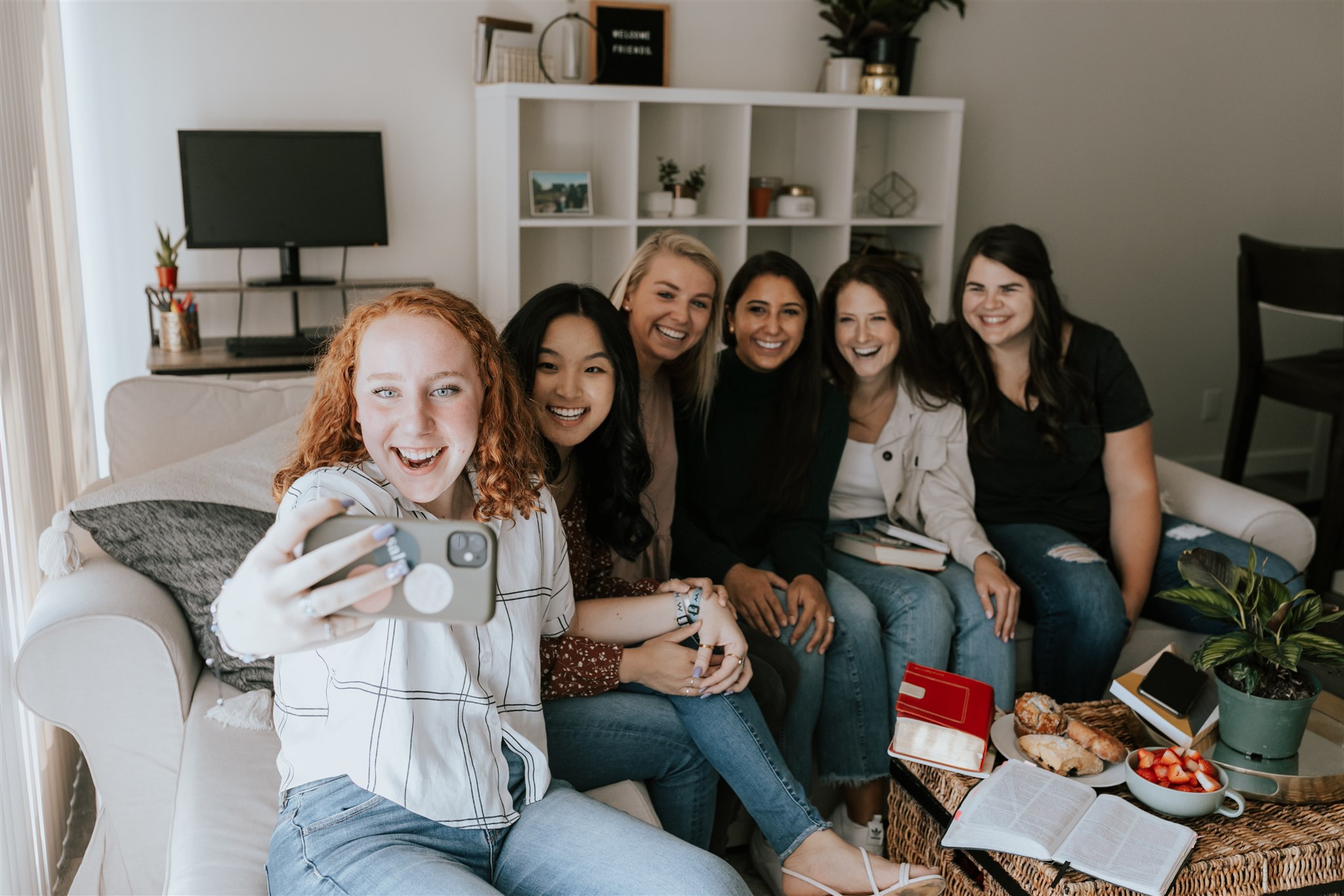 Women of various ages gather in a living room for Bible study and connection.