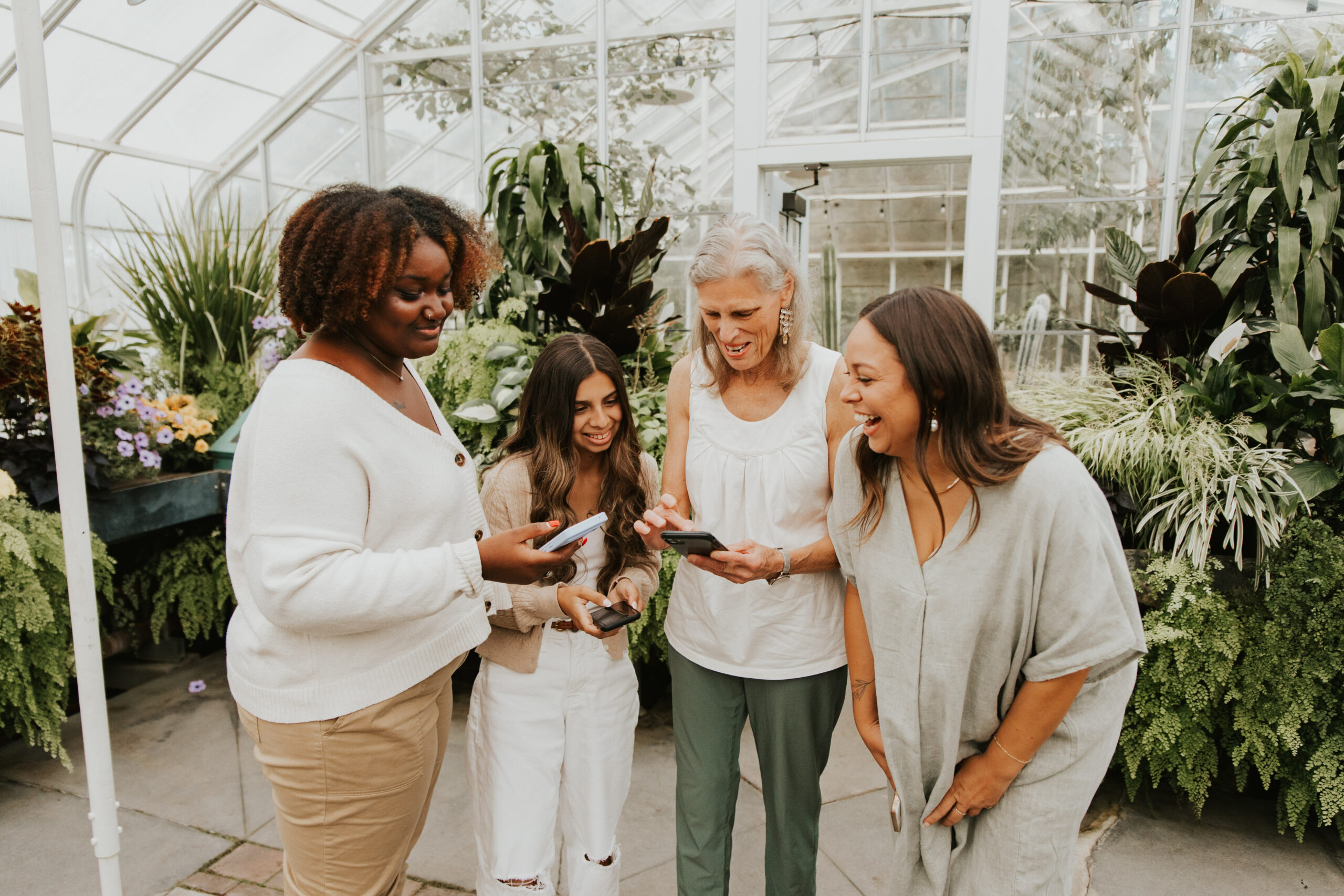 Women of all ages talk and laugh together in a semi circle.