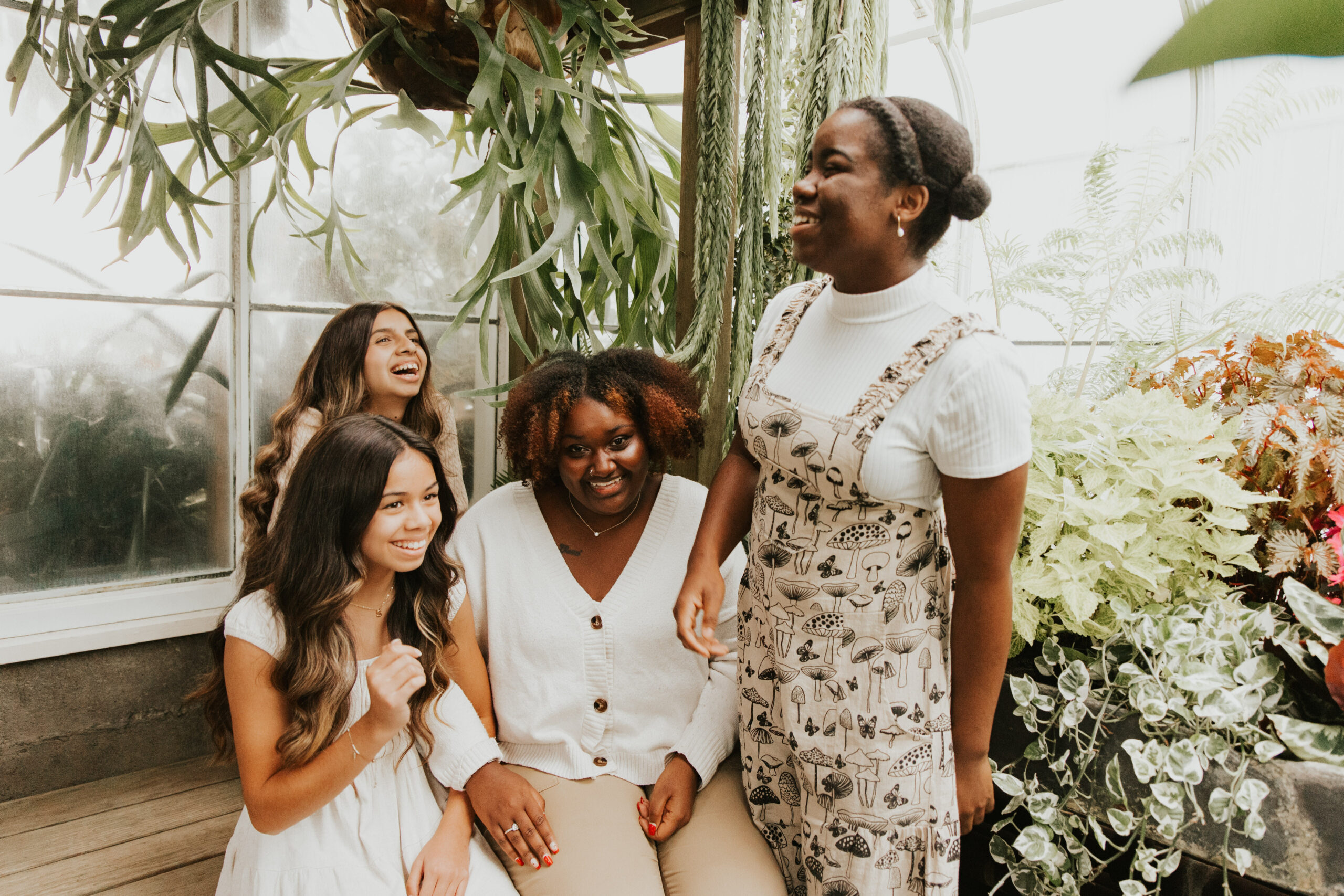 An intergenerational group of women laugh and talk together.