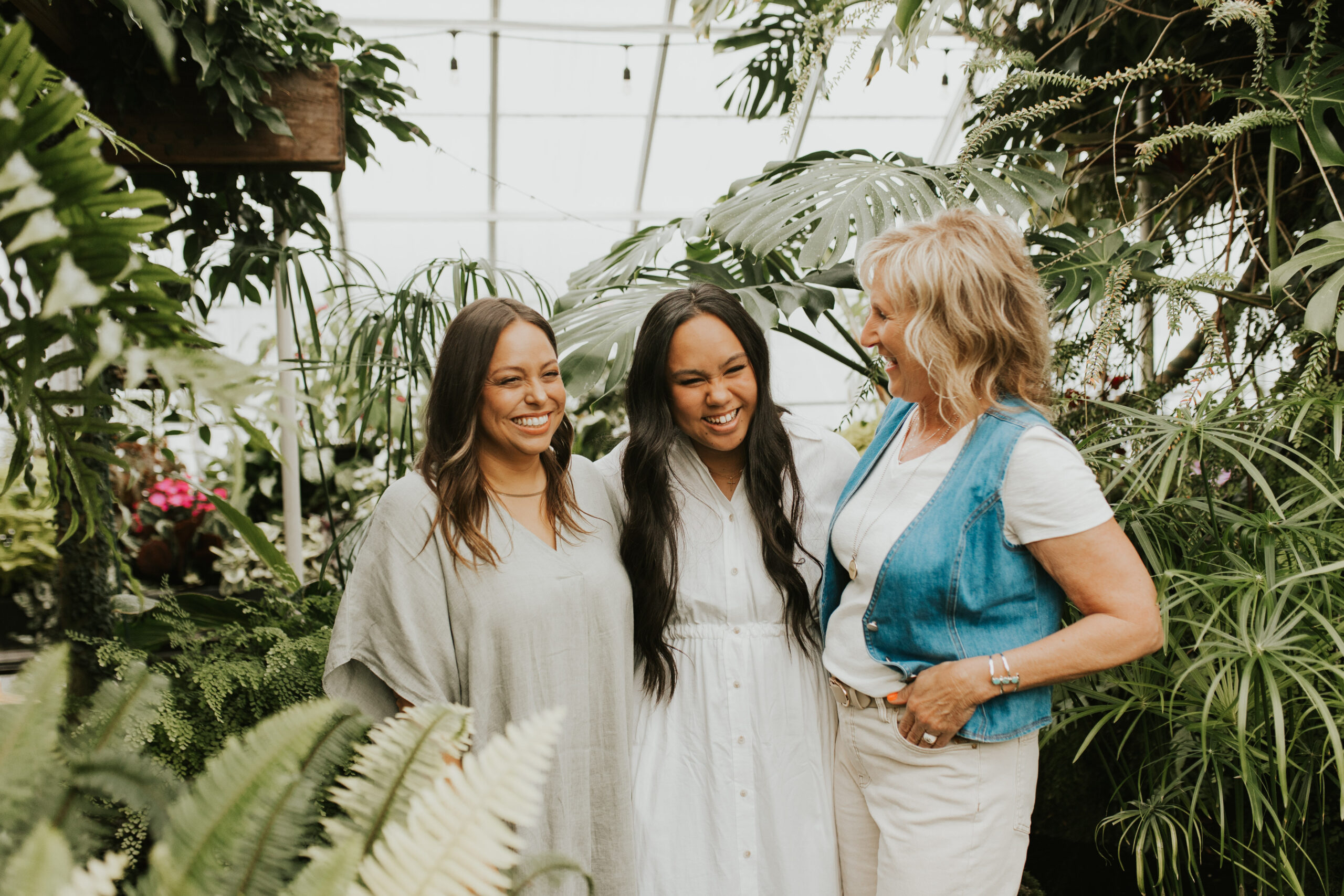 Three women gather around laughing and talking.